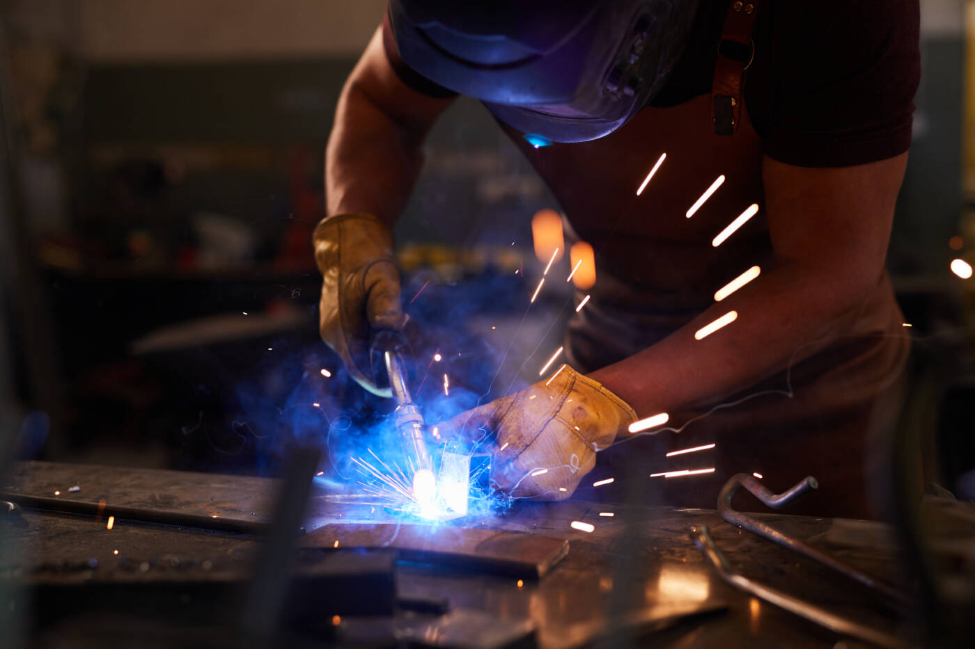 Artisan ferronnier métallier au travail dans son atelier
